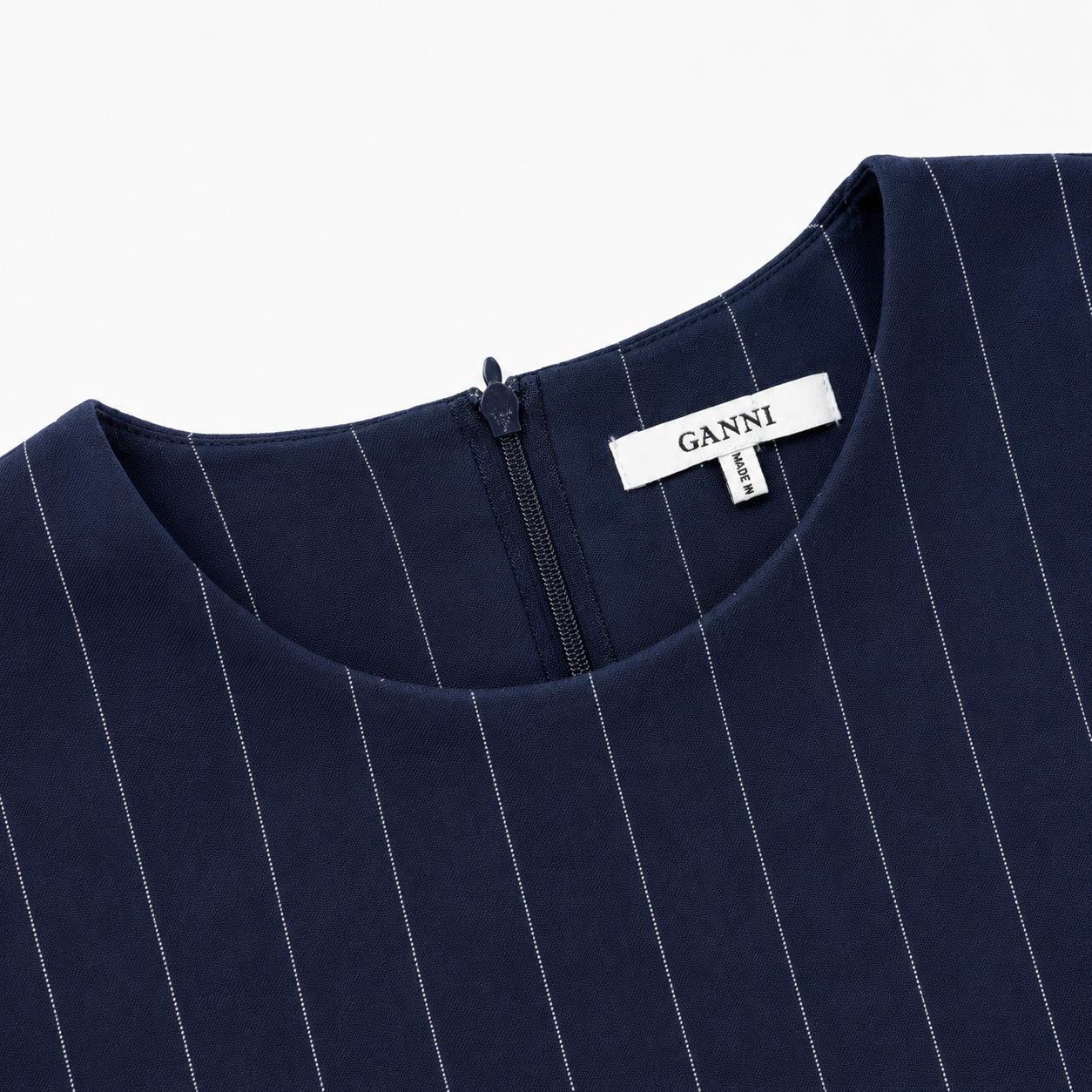 Navyblå GANNI stribet bluse i nålestribet design, størrelse 40, med lang ærme og rund hals, vist på model.