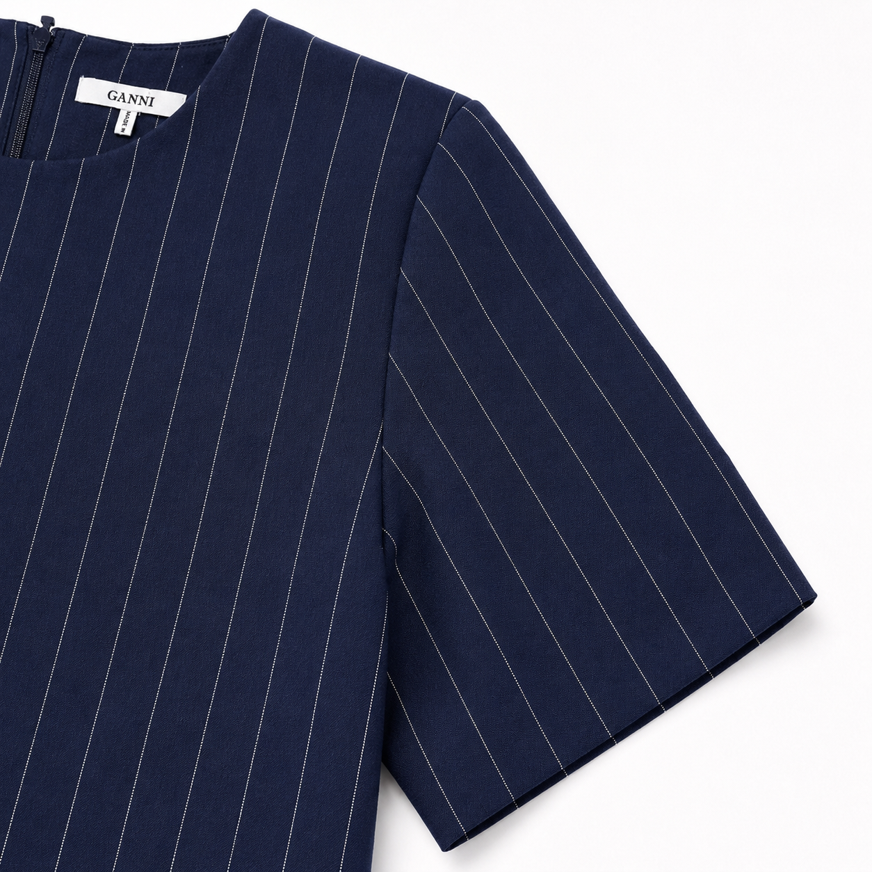 Navyblå Ganni nålestribet bluse i str. 40 med langærmet design og fin detalje, vist på model med neutral baggrund.